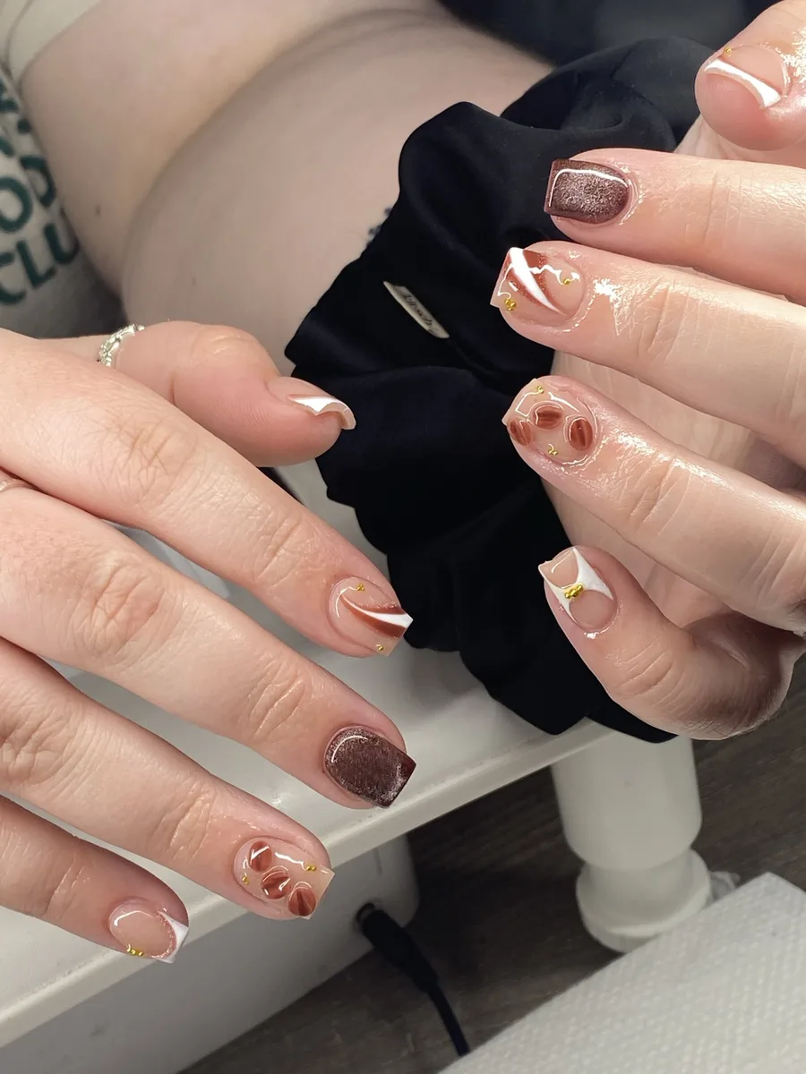 Brown and white swirl nail art with gold dots