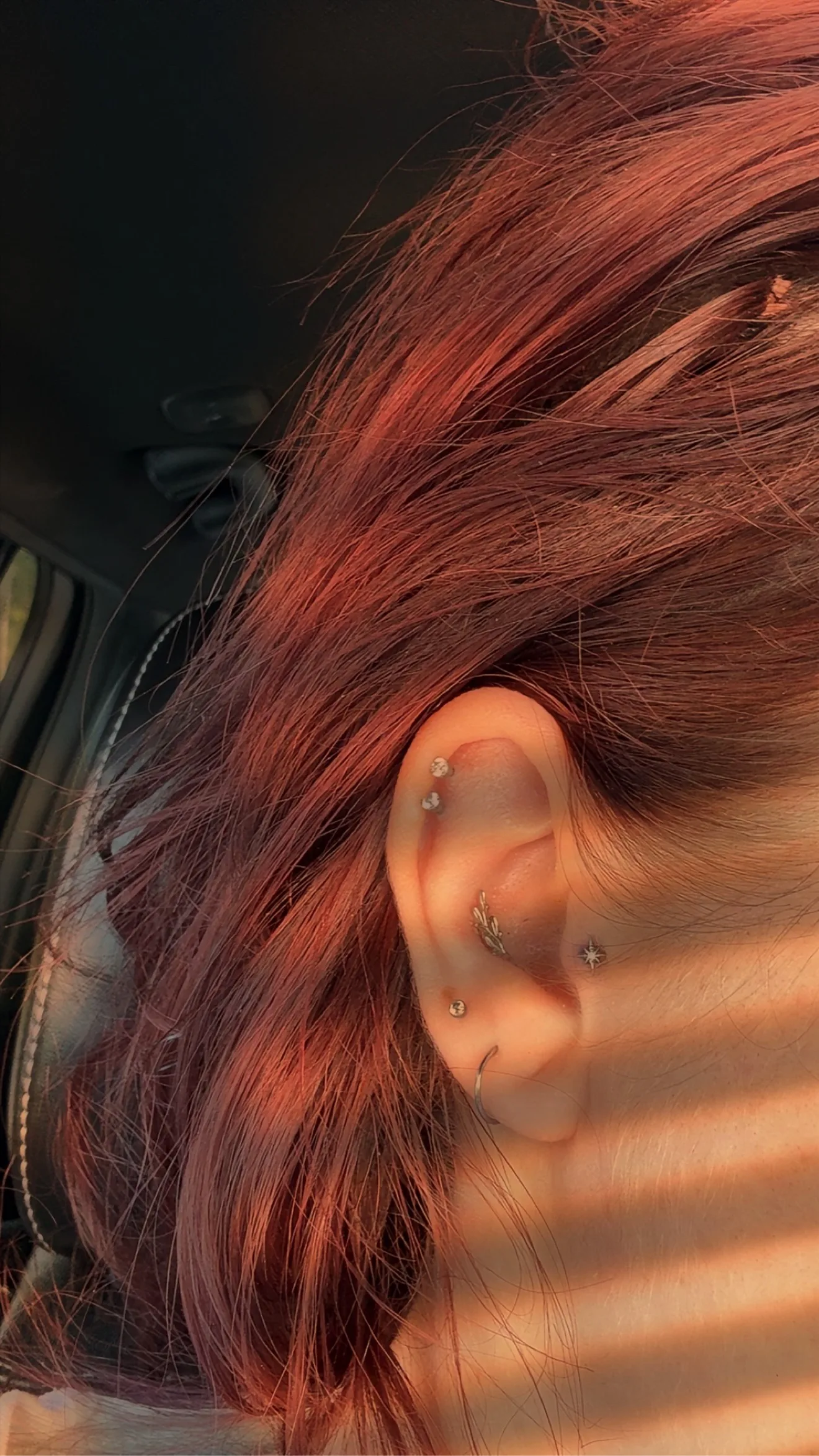 Close-up of an ear with helix, conch, tragus and lobe piercings